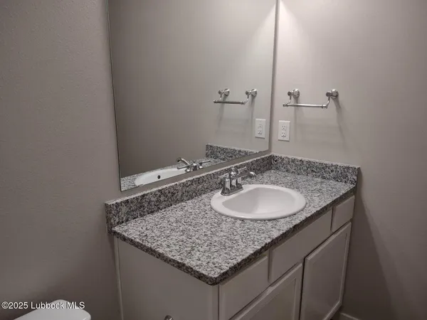 a bathroom with a granite countertop sink and a mirror