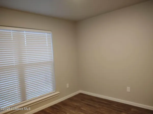 a view of a small space with wooden floor and a window