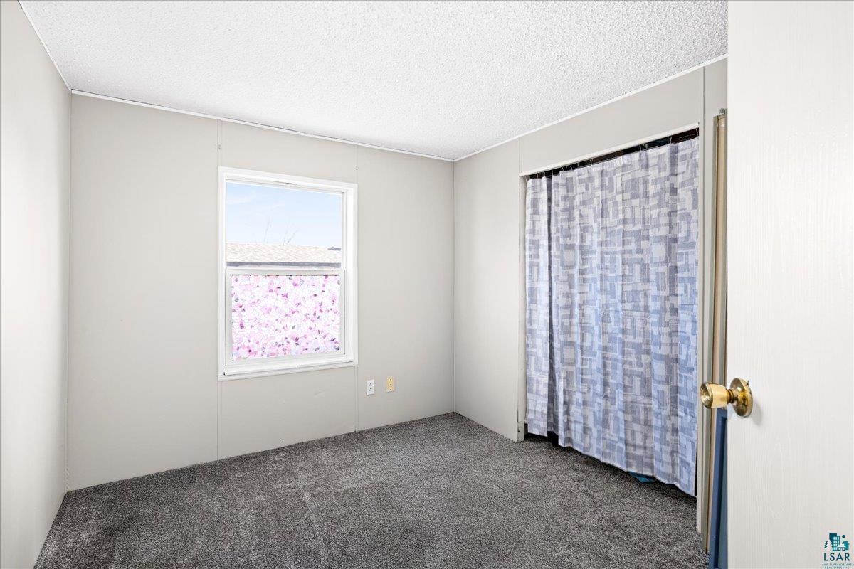 30 Ivy Drive Duluth, MN 55810 - Photo 13 of 21 Empty room with dark colored carpet and a textured ceiling