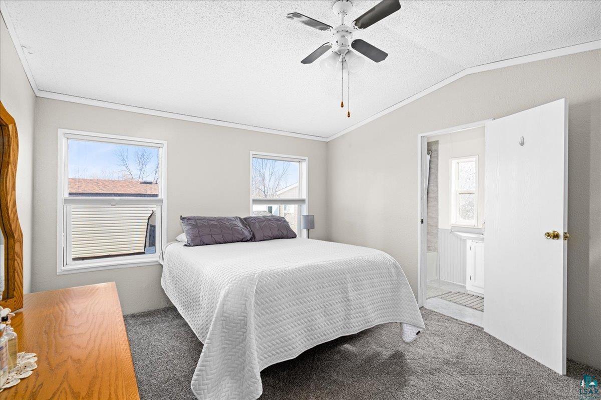 30 Ivy Drive Duluth, MN 55810 - Photo 14 of 21 Carpeted bedroom featuring ceiling fan, a textured ceiling, vaulted ceiling, and ornamental molding