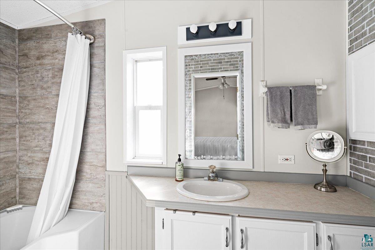30 Ivy Drive Duluth, MN 55810 - Photo 16 of 21 Bathroom featuring vanity, shower / bath combo, and ceiling fan