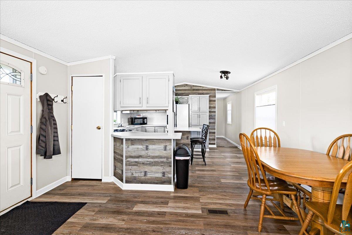 30 Ivy Drive Duluth, MN 55810 - Photo 5 of 21 Kitchen featuring lofted ceiling, dark hardwood / wood-style floors, ornamental molding, white fridge, and a textured ceiling