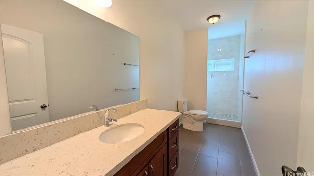 a bathroom with a granite countertop sink a toilet and shower