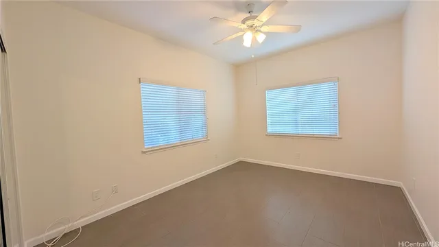 an empty room with a window and a fan