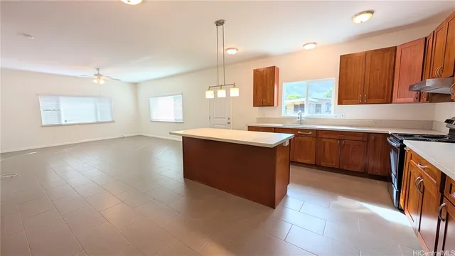 a kitchen with stainless steel appliances granite countertop a sink a stove top oven a counter space and cabinets