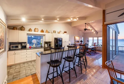 a kitchen with stainless steel appliances a dining table chairs stove and cabinets