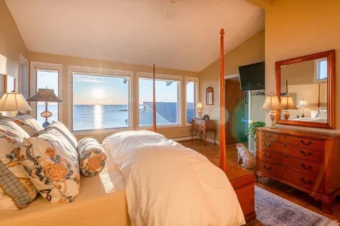 a spacious bedroom with a bed and wooden floor