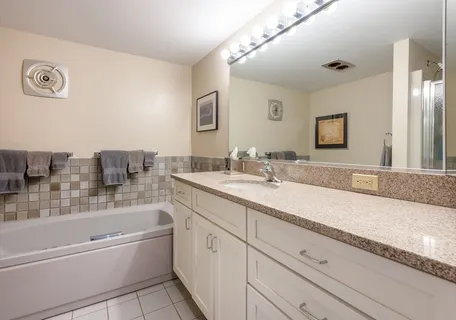 a bedroom with a bed and a couch next to a window