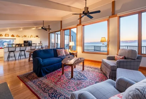 a living room with furniture a ceiling fan and a large window