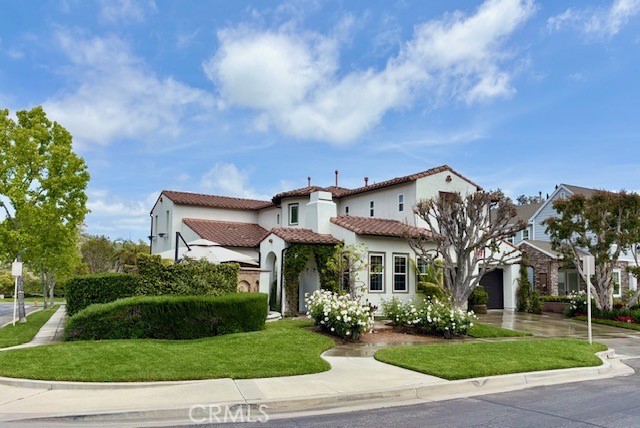 a view of a white house with a big yard and potted plants