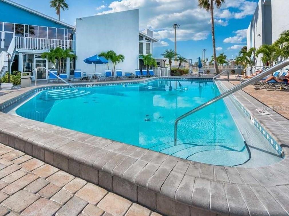 273 Rex Place, Unit G Madeira Beach, FL 33708 - Photo 18 of 42 a view of a swimming pool with chairs