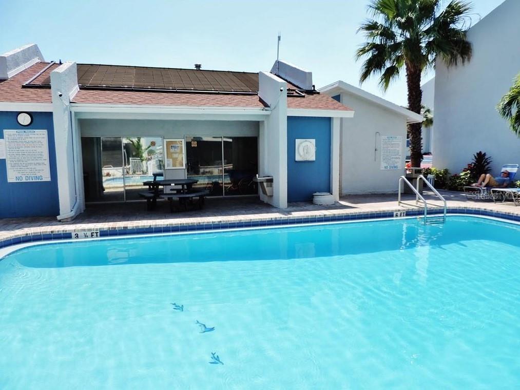 273 Rex Place, Unit G Madeira Beach, FL 33708 - Photo 20 of 42 a view of swimming pool with lawn chairs and potted plants