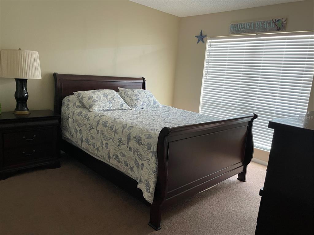 273 Rex Place, Unit G Madeira Beach, FL 33708 - Photo 33 of 42 a bed sitting in a bedroom next to a window