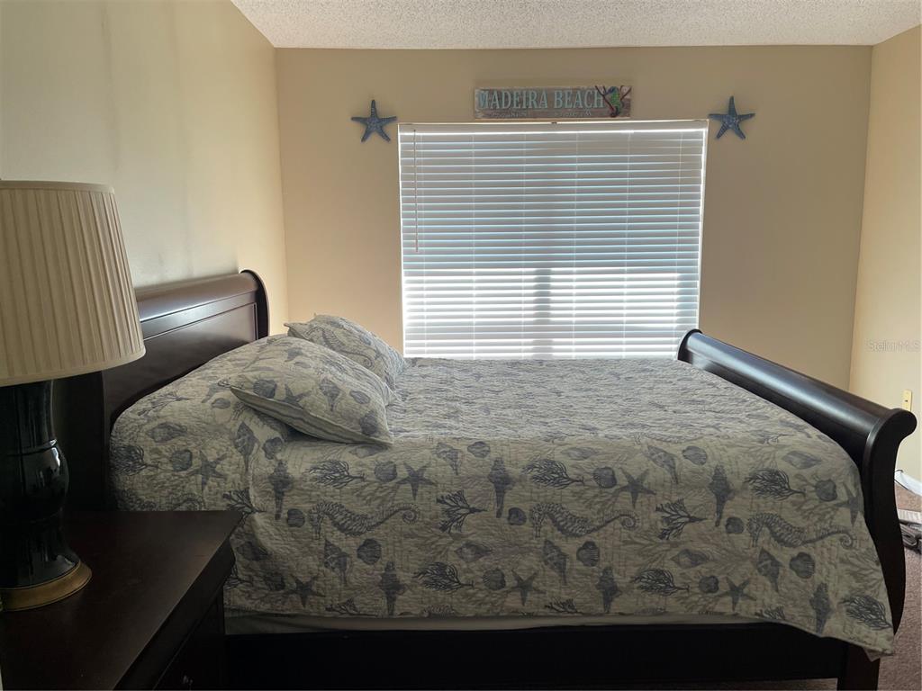 273 Rex Place, Unit G Madeira Beach, FL 33708 - Photo 34 of 42 a bedroom with a bed and a window