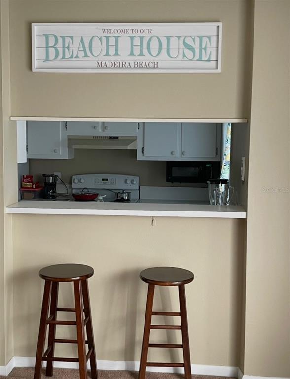 273 Rex Place, Unit G Madeira Beach, FL 33708 - Photo 37 of 42 a kitchen with a refrigerator and cabinets