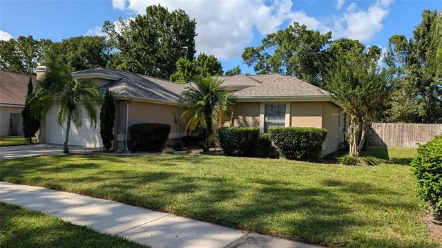 a view of a house with a yard and potted plants