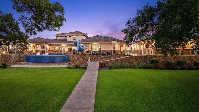 an aerial view of a house with a garden and lake view