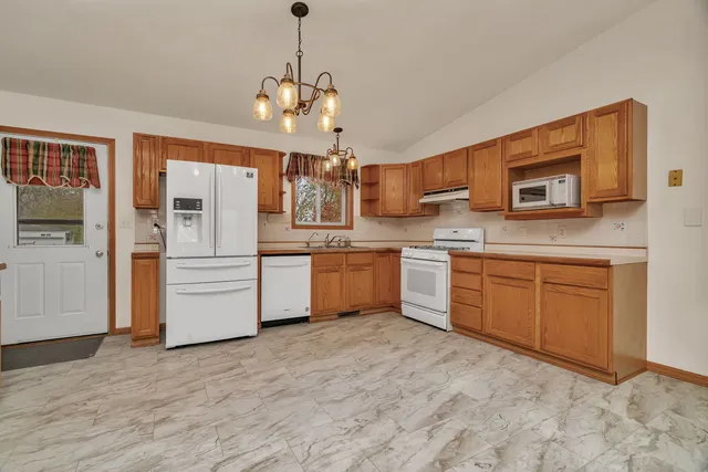 a view of empty room with a kitchen and fireplace