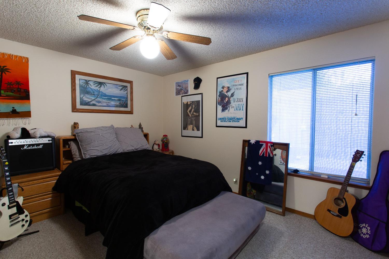 1570 Pine Drive Lemoore, CA 93245 - Photo 11 of 24 a bedroom with a bed and a chandelier