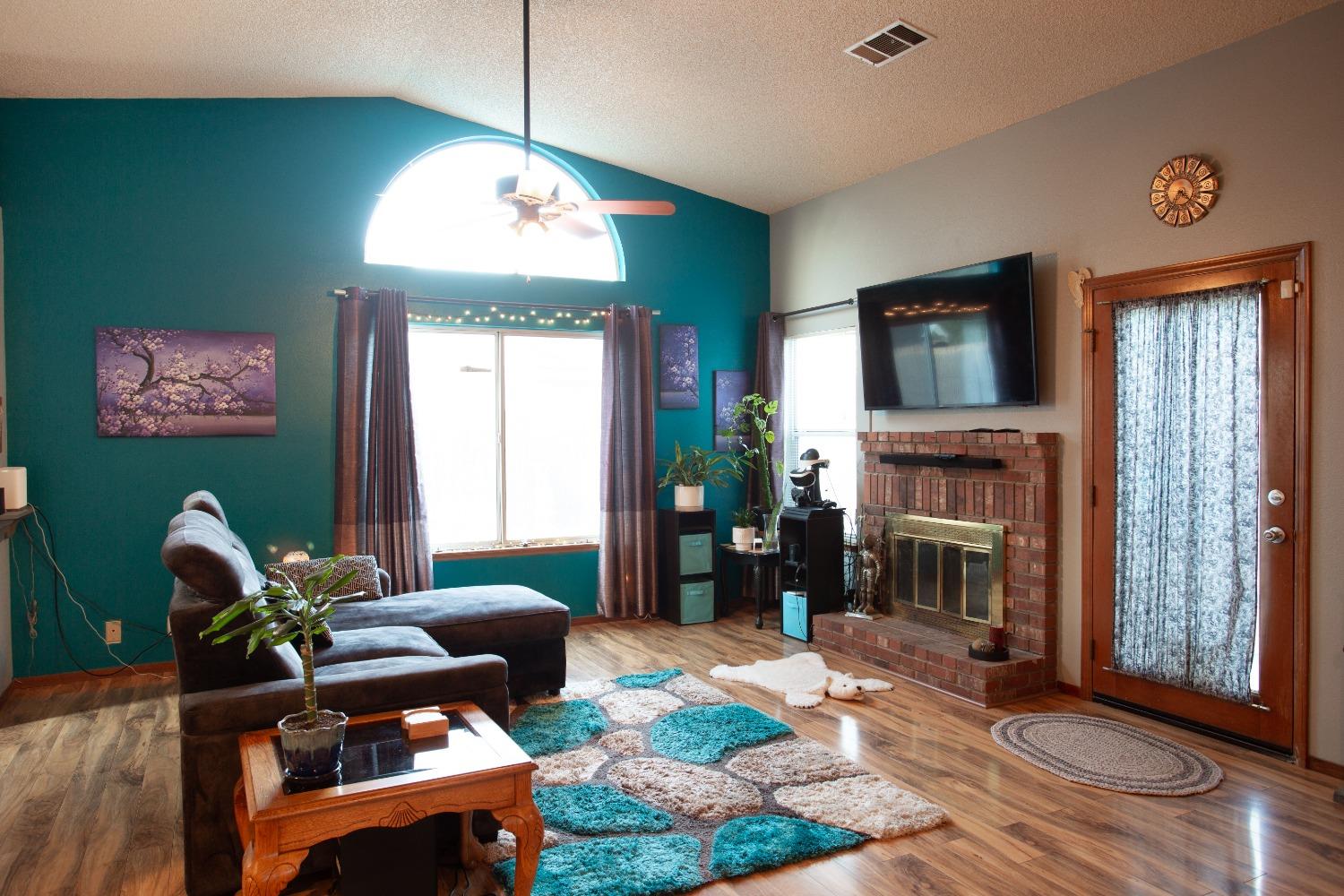 1570 Pine Drive Lemoore, CA 93245 - Photo 5 of 24 a living room with furniture a fireplace and a flat screen tv