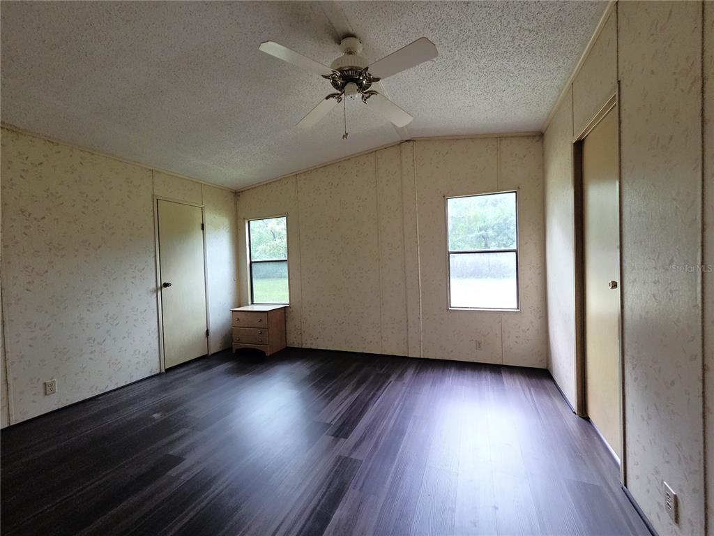 14822 Dilbeck Drive Spring Hill, FL 34610 - Photo 14 of 40 an empty room with wooden floor and windows