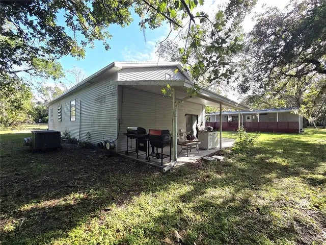 a view of a backyard with plants and large tree