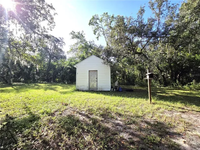 a view of a house with a backyard and chairs
