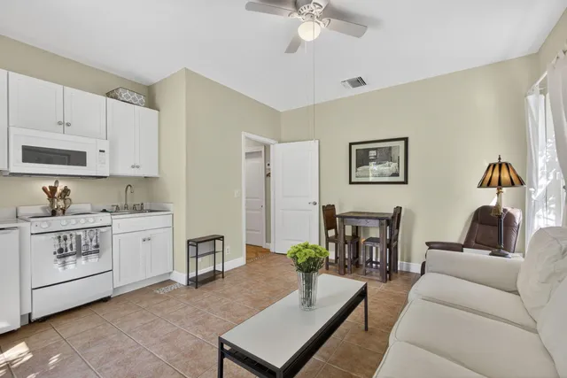 a living room with furniture and view of kitchen