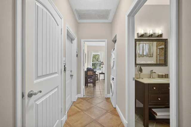 a view of a hallway with a livingroom and a bathroom with a sink