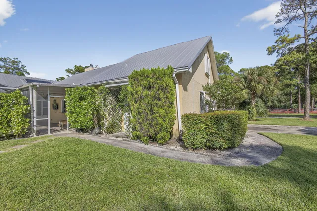a view of a house with a big yard and potted plants