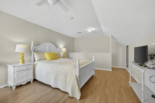 a bedroom with a bed and a flat tv screen on dresser