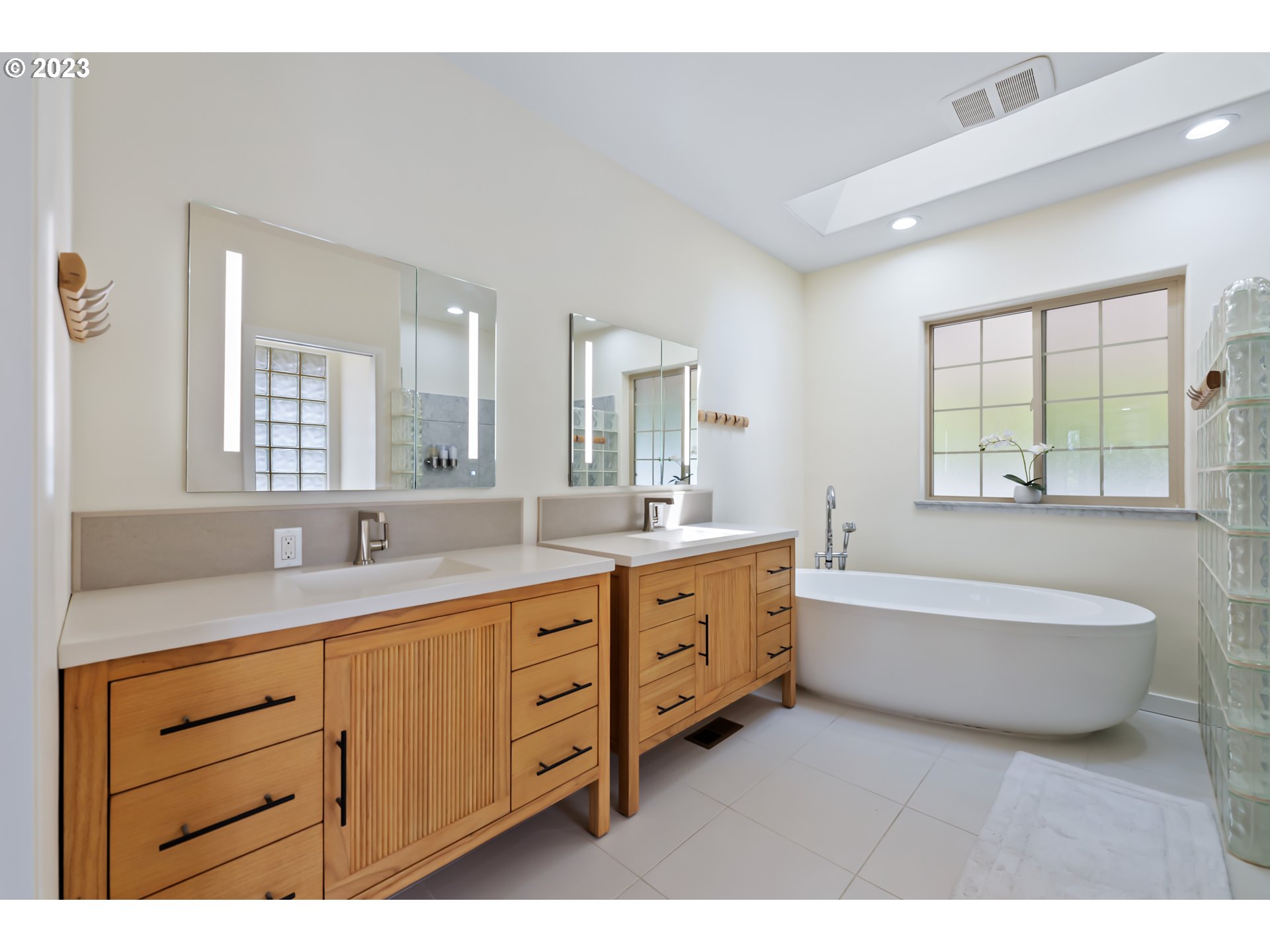 19630 McDonald Road Brookings, OR 97415 - Photo 18 of 36 a spacious bathroom with a granite countertop double vanity sink a mirror and a bathtub