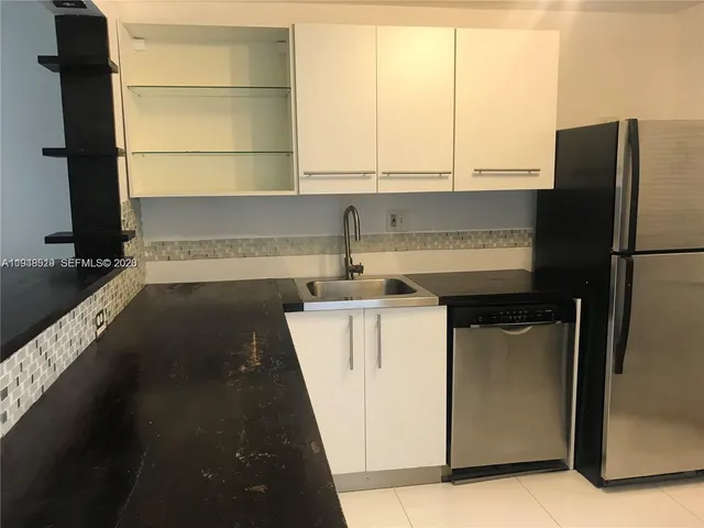 a kitchen with a refrigerator and a sink
