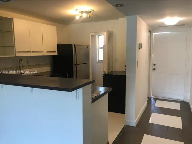 a kitchen with granite countertop a refrigerator and a sink