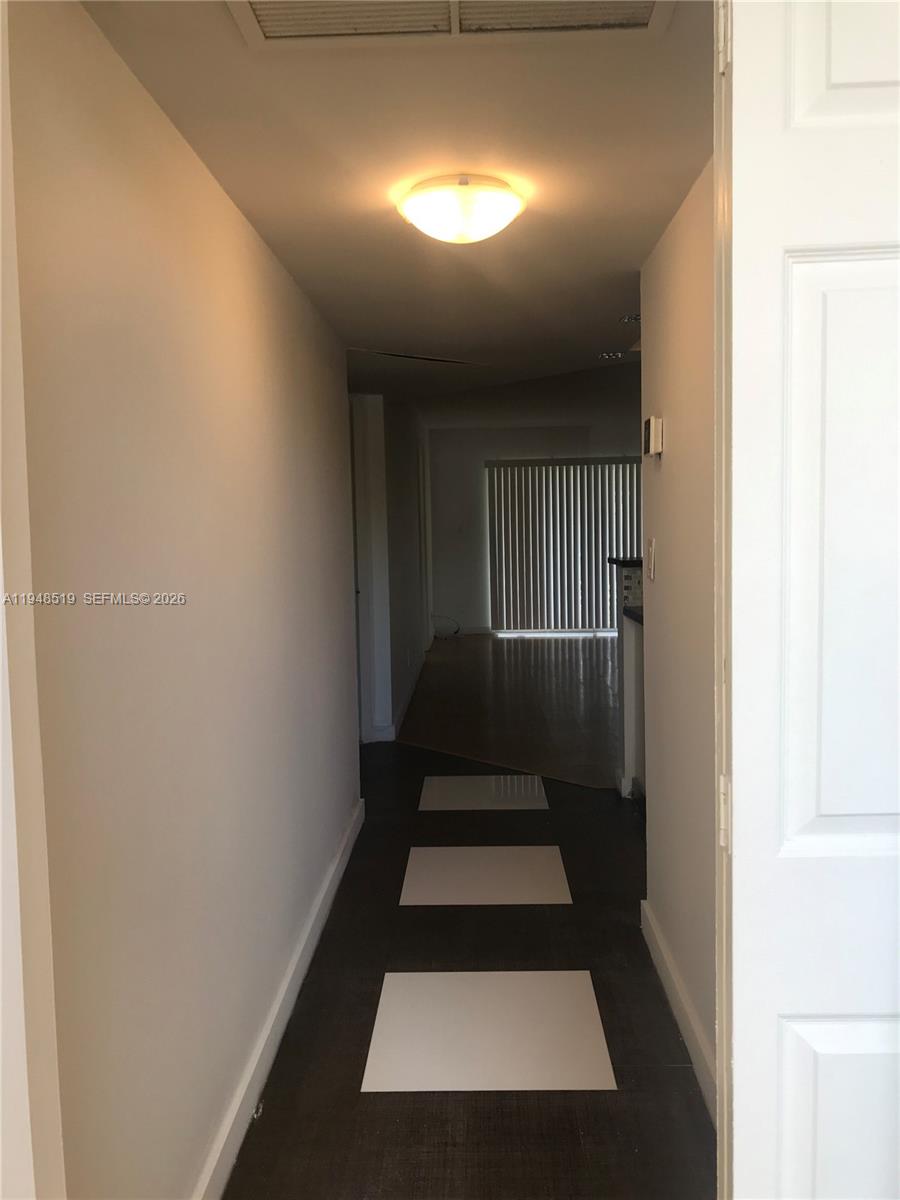 8040 North Colony Circle, Unit 101 Tamarac, FL 33321 - Photo 4 of 15 a view of a hallway with wooden floor and a window