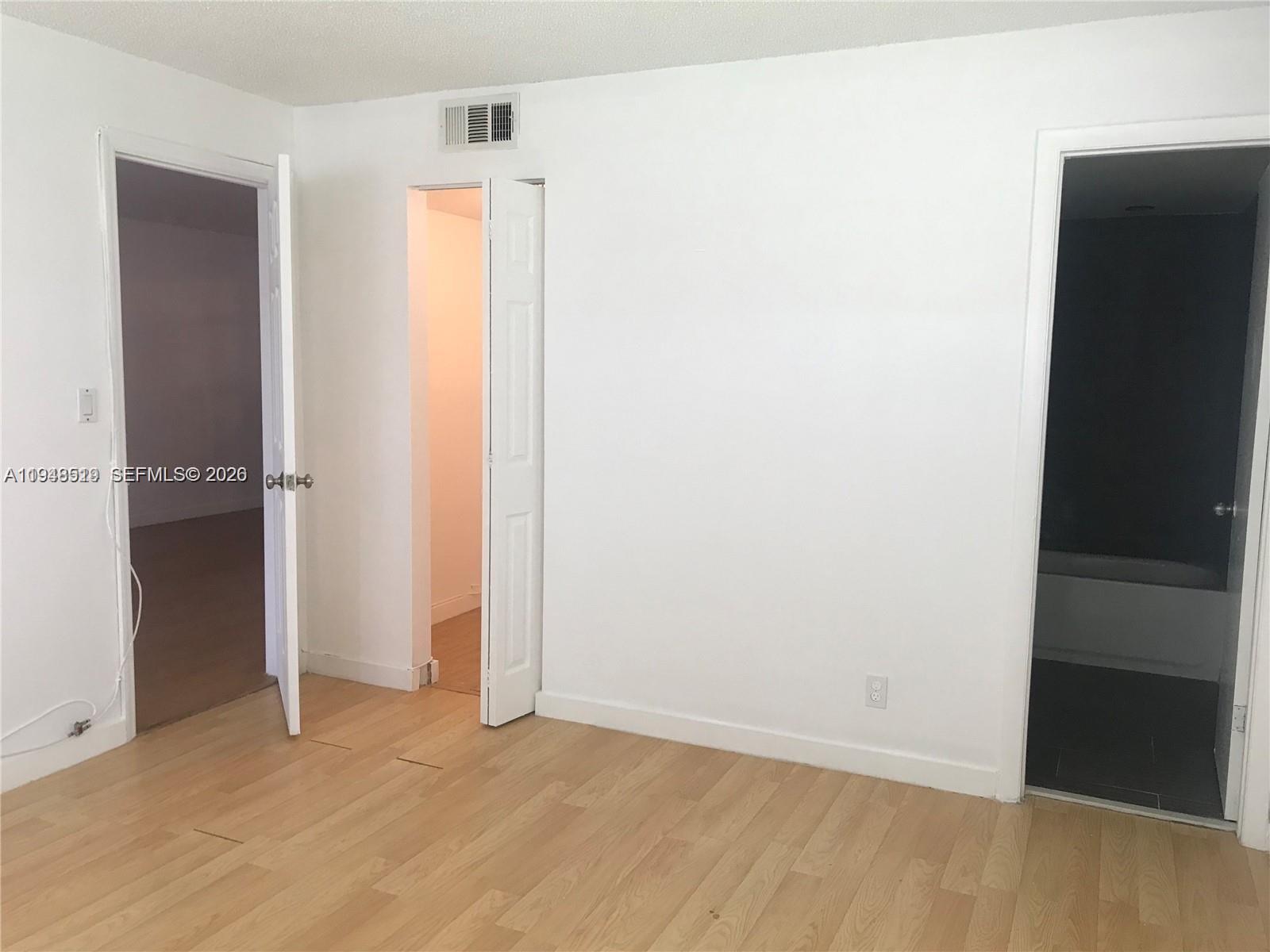 8040 North Colony Circle, Unit 101 Tamarac, FL 33321 - Photo 6 of 15 an empty room with wooden floor and closet