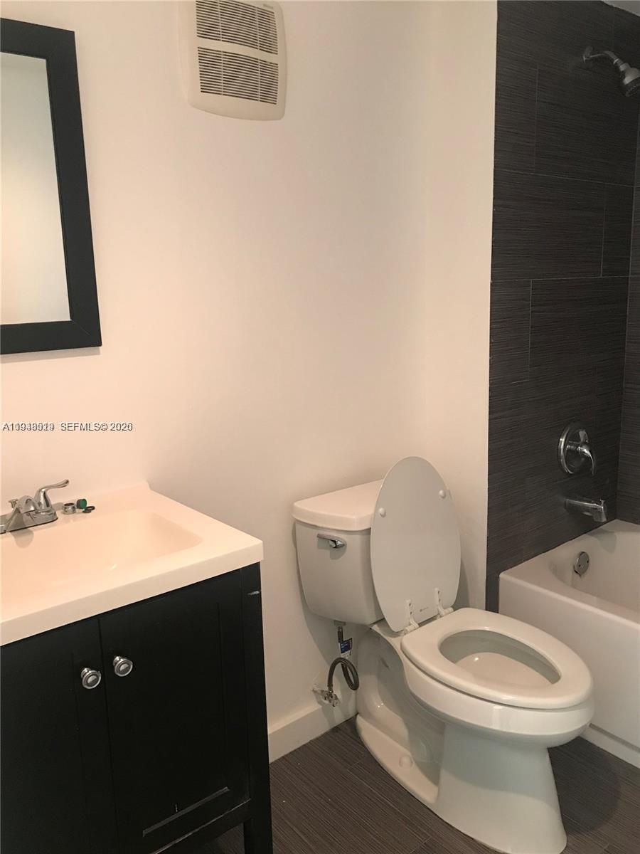 8040 North Colony Circle, Unit 101 Tamarac, FL 33321 - Photo 7 of 15 a bathroom with a toilet a sink and mirror