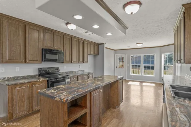 a kitchen with granite countertop a stove and a sink