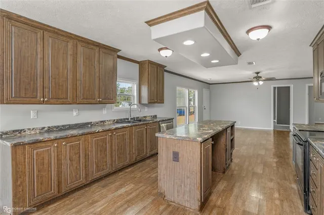 a kitchen with granite countertop a sink appliances and cabinets