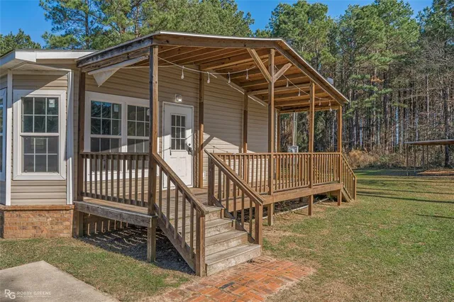 a view of a house with a small yard and wooden fence
