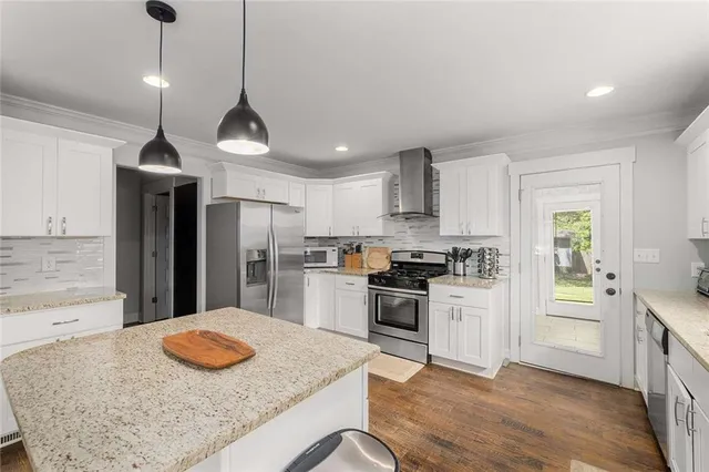 a kitchen with stainless steel appliances granite countertop a sink a stove a refrigerator cabinets and living room view