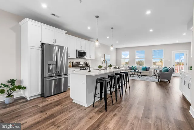 a kitchen with sink a refrigerator and a stove top oven