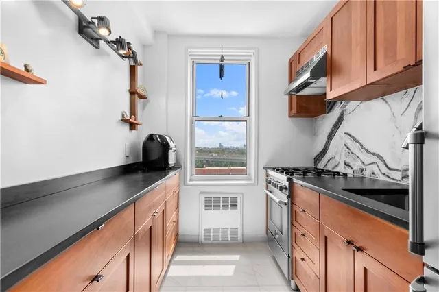 a kitchen with stainless steel appliances granite countertop a stove and a refrigerator