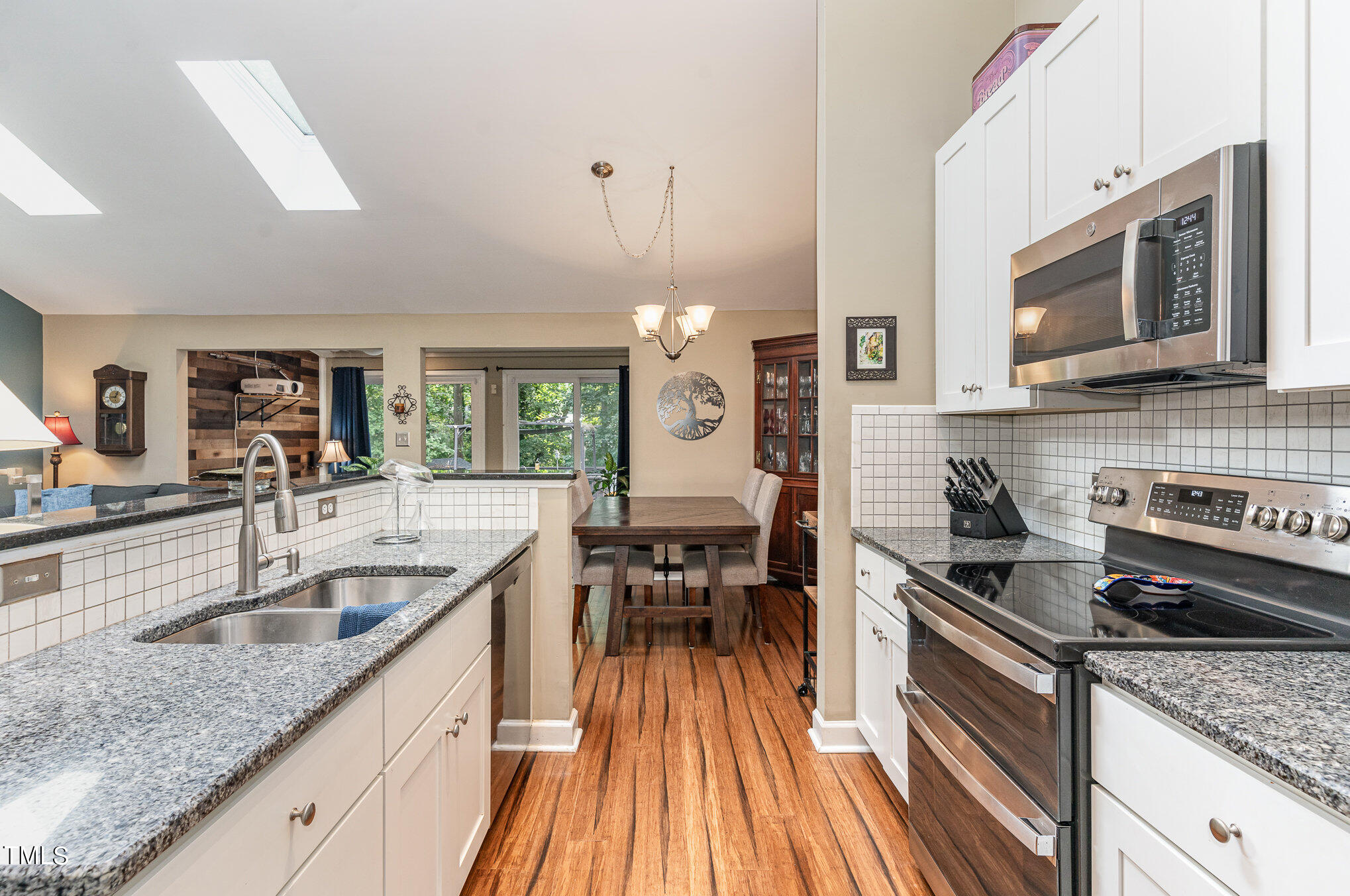 529 Ashebrook Drive Raleigh, NC 27609 - Photo 10 of 35 a kitchen with granite countertop a sink dishwasher stove and oven with wooden floor