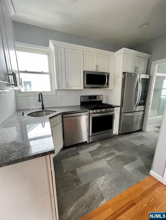 345 Kaplan Avenue, Unit 2 Hackensack, NJ 07601 - Photo 6 of 14 a kitchen with stainless steel appliances granite countertop a sink a stove a microwave a refrigerator a counter space and cabinets