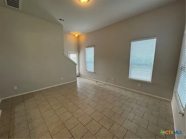an empty room with a fireplace and windows