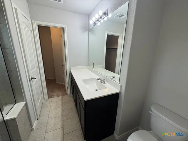 a bathroom with a sink and a glass door shower