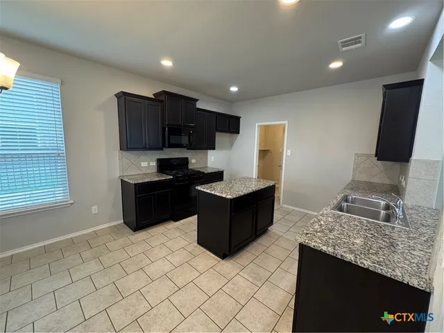 a kitchen with granite countertop cabinets and steel stainless steel appliances