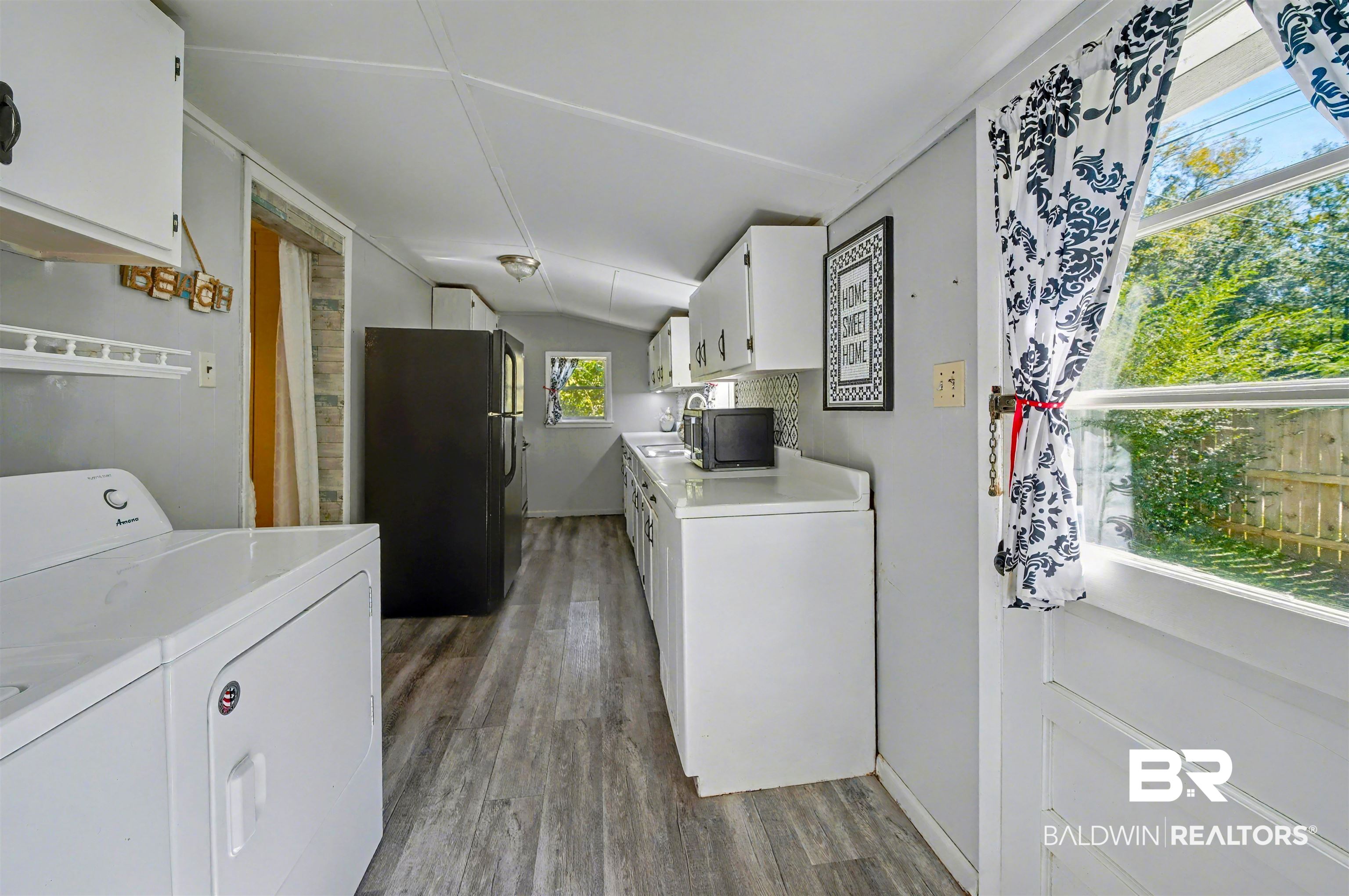 209 West Magnolia Avenue Foley, AL 36535 - Photo 22 of 23 Laundry area featuring light wood-type flooring, vaulted ceiling, and independent washer and dryer
