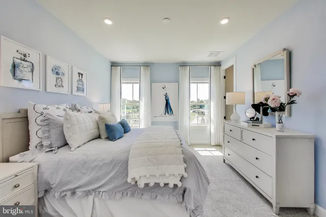 a spacious bedroom with a large bed and dresser with mirror